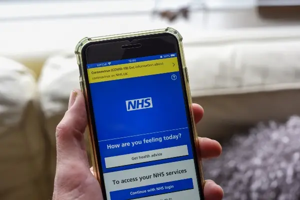 Person using NHS app on smartphone.